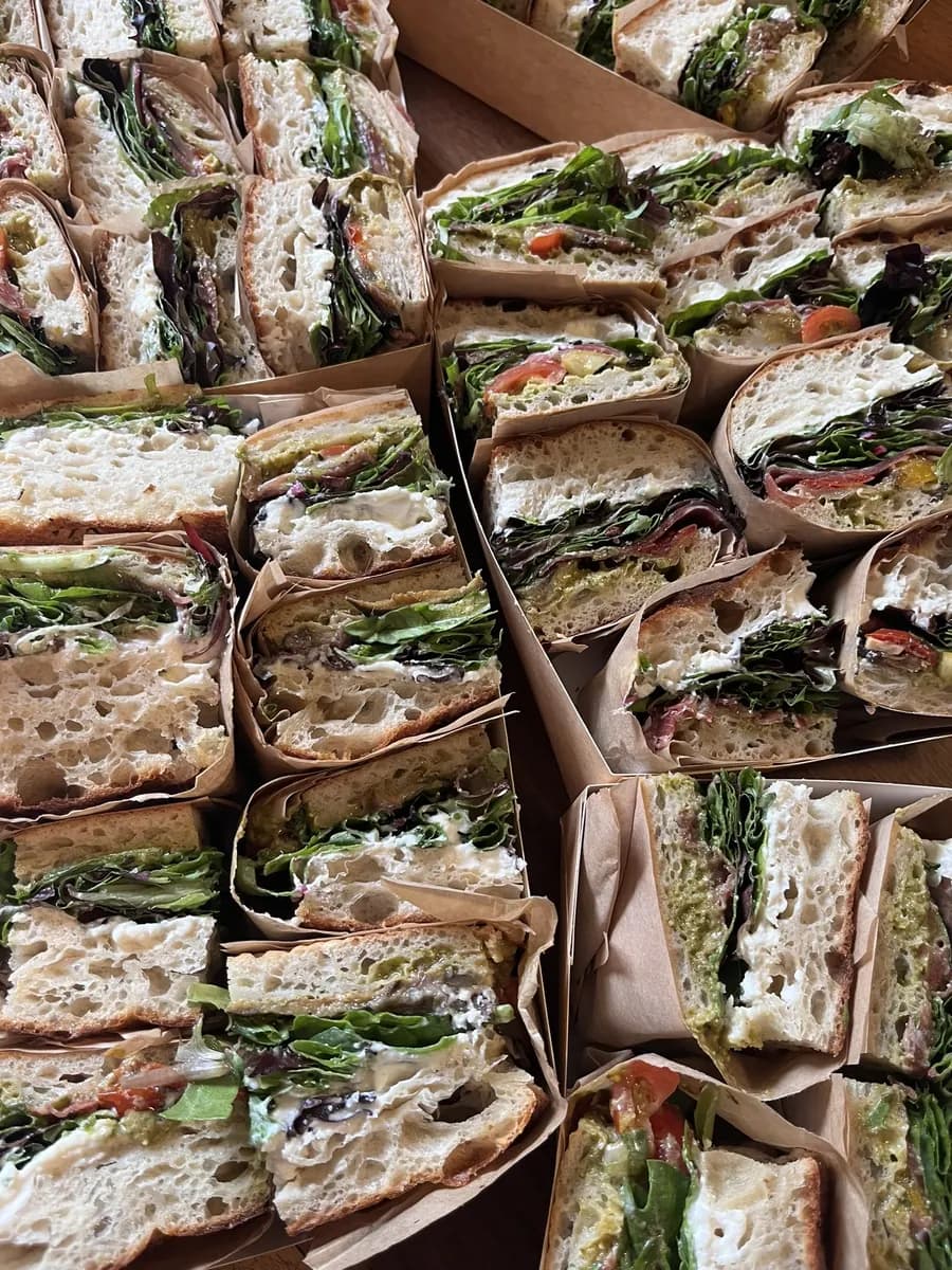 Plateau de sandwichs focaccia coupés et emballés dans du papier kraft, prêts pour un buffet