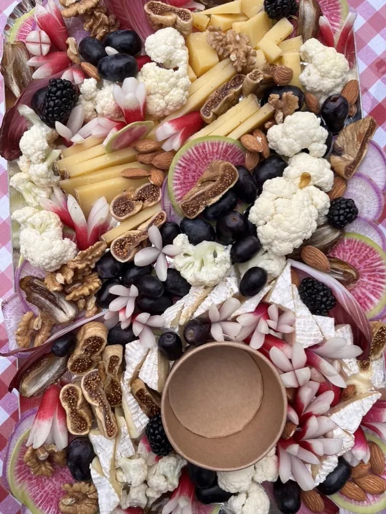 Planche de fromages et charcuterie avec chou-fleur, mûres, olives noires, noix et figues séchées